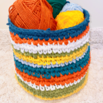 A photograph of a crochet woven basket that consists of vibrant colors