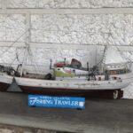 A photograph of a mini ship detailed with various sail necessities