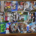 Various recycable items organized into square boxes with various items such as cardbaord