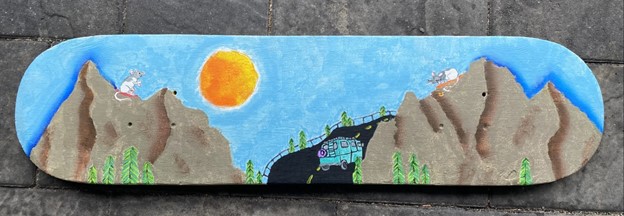 This image is of a skateboard that is painted with two mountain tops